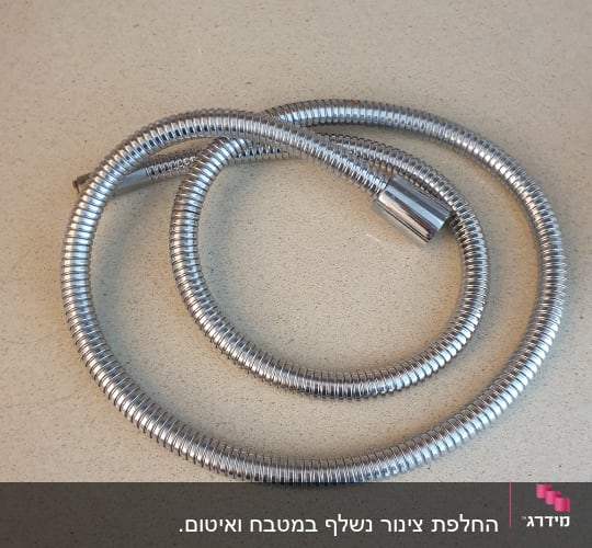 צינור מתכת גמיש על משטח בהיר